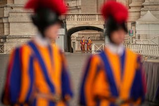 Pontifical Swiss guards stand in St Peter's Square before the arrival of the body of Pope Francis, who will lie in state at St Peter's Basilica for three days, at the Vatican, Wednesday, 23 April 2025